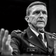 Fotografía en blanco y negro de Michael Flynn en uniforme testificando ante el Congreso con un micrófono.