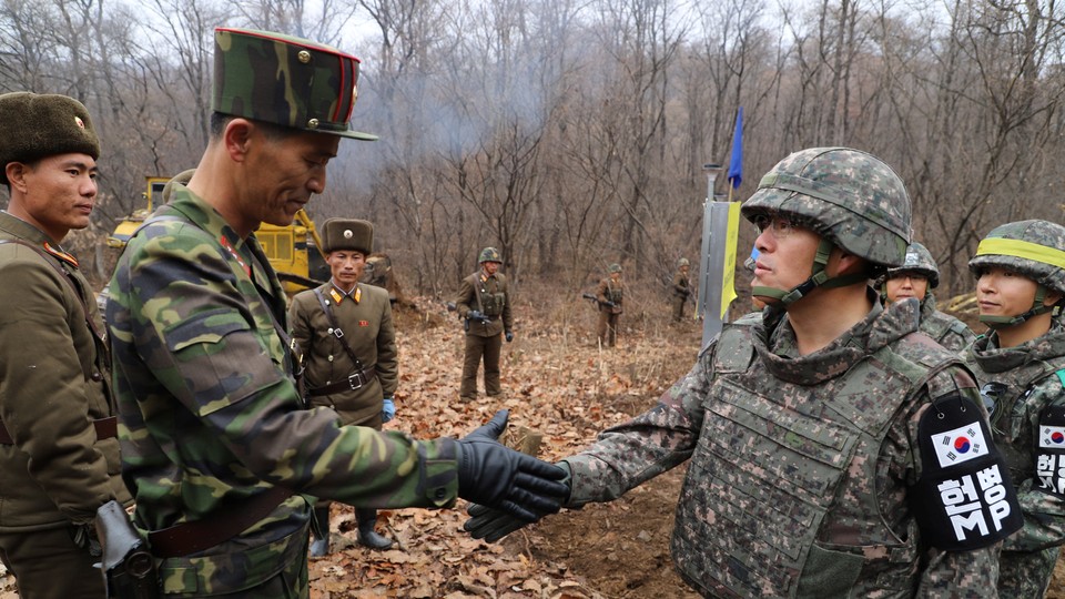 A South Korean military officer and a North Korean military officer shake hands near the demilitarized zone separating the two Koreas on November 22.