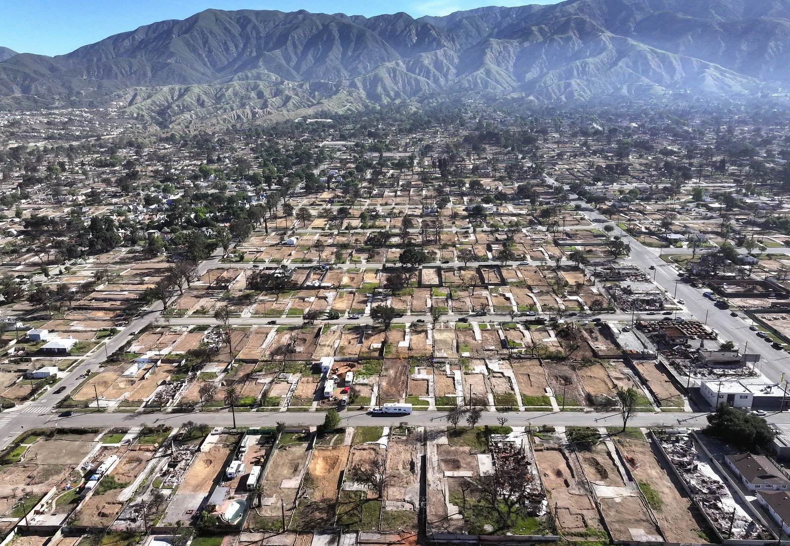 An aerial view of empty lots in a residential neighborhood, after being cleared of wildfire debris