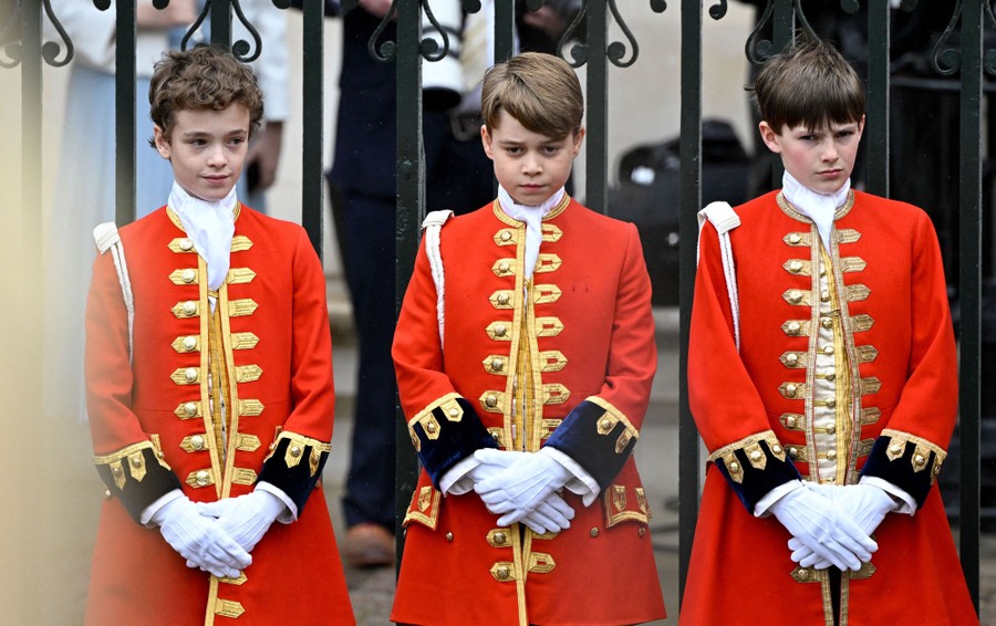 Three boys wearing decorative uniforms stand side-by-side.