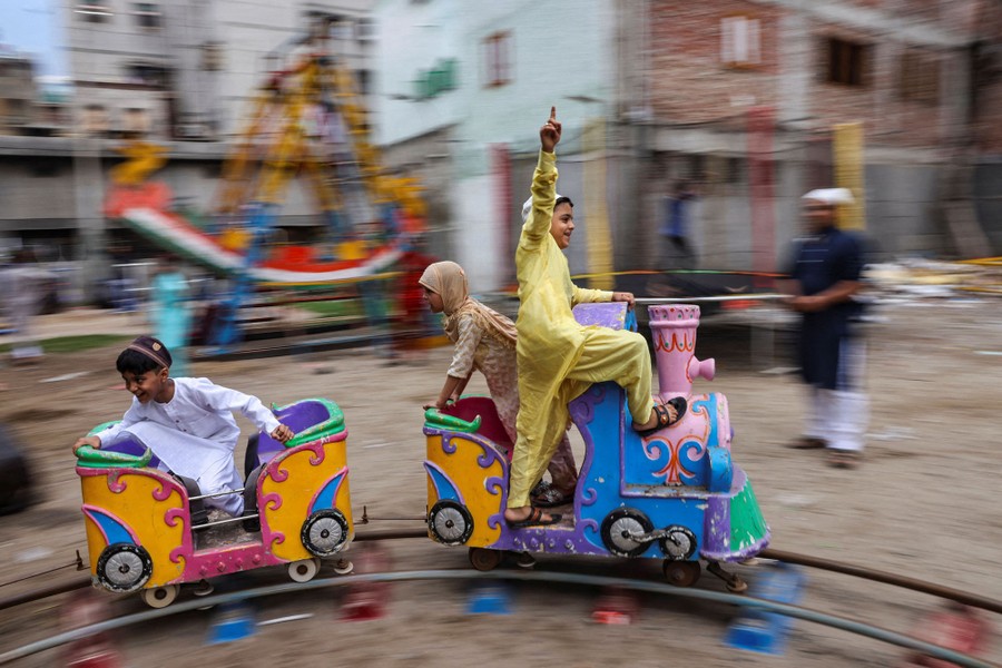 Children play on a toy train in a street