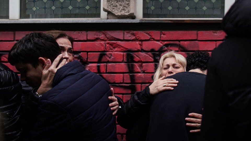 People react outside the Vladislav Ribnikar elementary school in Serbia's capital, Belgrade, on May 4, 2023, a day after a 13-year-old suspect shot dead eight fellow students and a security guard after allegedly drawing up a kill list