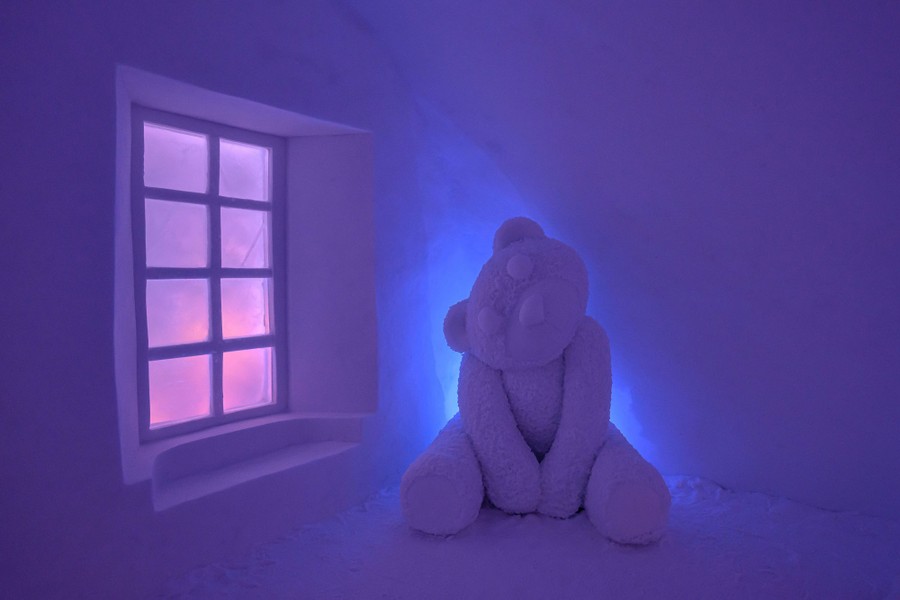 Căn phòng được chạm khắc bằng tuyết, có cửa sổ, tác phẩm điêu khắc gấu bông lớn và ánh sáng đầy tâm trạng