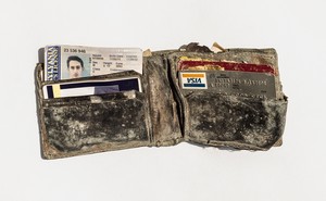 Dusty wallet containing ID, credit card, and other items