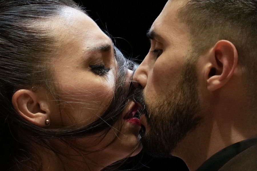 A couple hold their faces very close together during a tango competition.