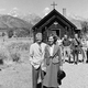 A black-and-white photo of Jimmy and Rosalynn Carter in front of a rural church and a small group of people