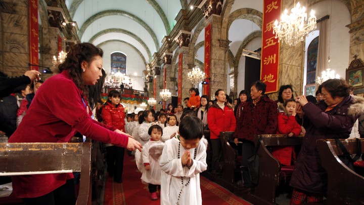 Chinese children walk down the aisle during Christmas Mass at a Catholic church in Beijing.