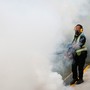 A worker uses insecticide to fog the common area of a public housing estate in Singapore, in an area where 189 cases of locally-transmitted Zika have been reported.