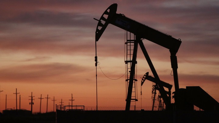 An oil rig silhouetted on a twilight sky