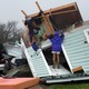 A woman stands on a destroyed house in Fulton, Texas.