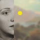 A woman's face against the blurred background of a countryside