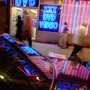 The neon lights of an adult-video store are reflected on a car.