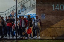 Migrants stand at a processing center as they wait for a bus to Chicago, in downtown Brownsville, Texas, U.S., October 24, 2023.