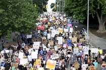 Hundreds of pro-abortion-rights demonstrators march in a street.