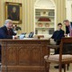 President Trump, accompanied by senior aides, makes a phone call in the Oval Office.