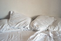 Rumpled sheets and pillows on a bed