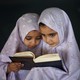 Two young girls reading the Quran