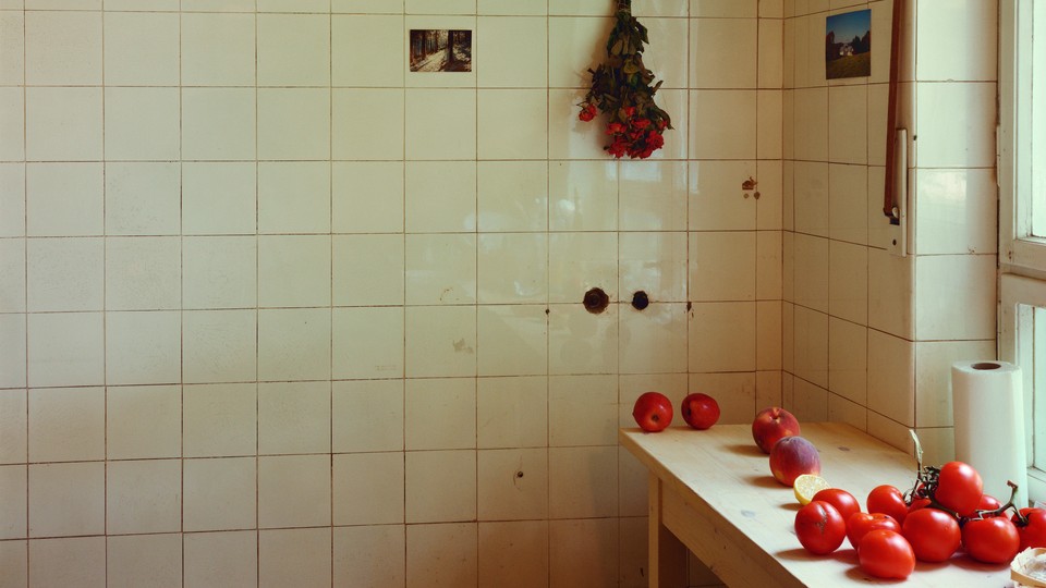 A brightly lit room with tiled walls and a table with tomatoes and peaches on them