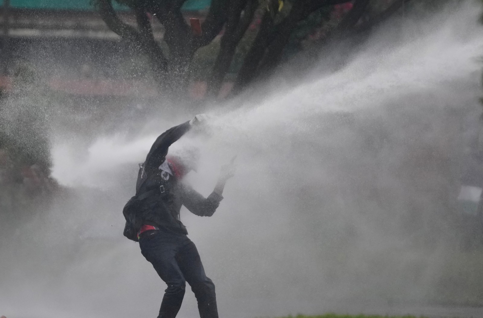 A demonstrator is hit by a jet of water from a police water cannon in Colombia.