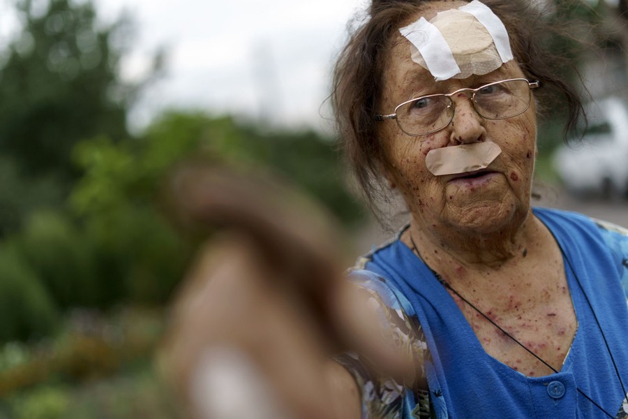 A bandaged and wounded woman points offscreen.