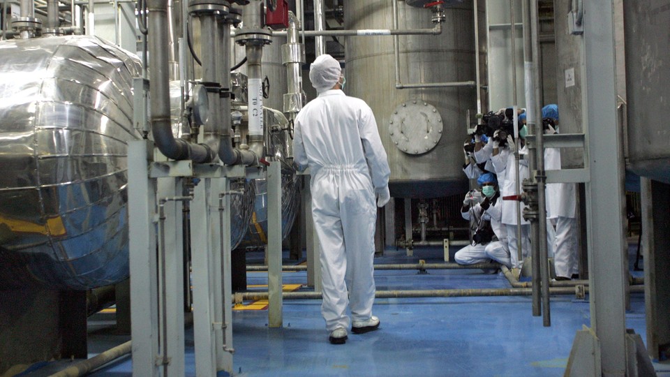 A technician in scrubs walking among machinery