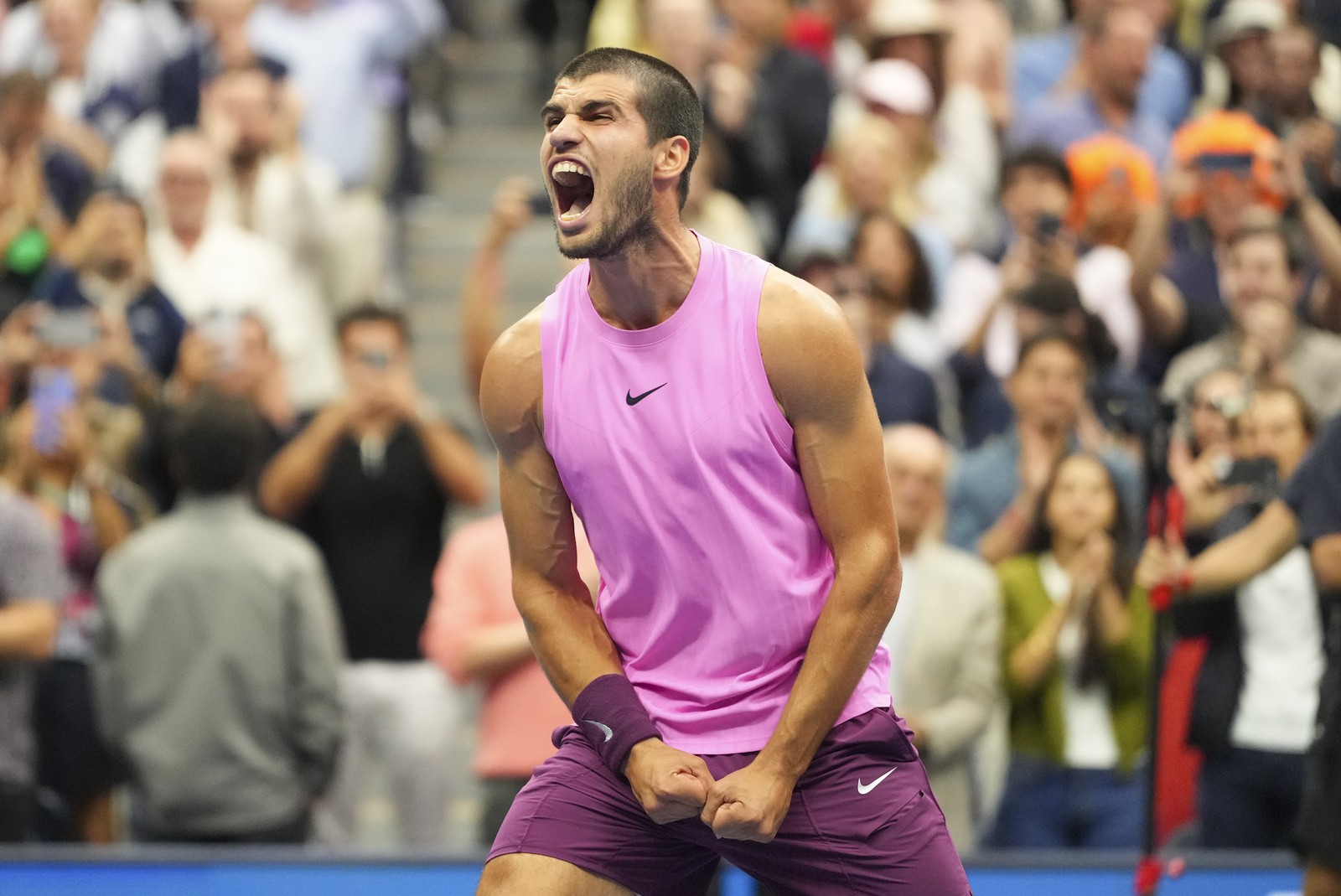 A tennis player shouts after winning a match.