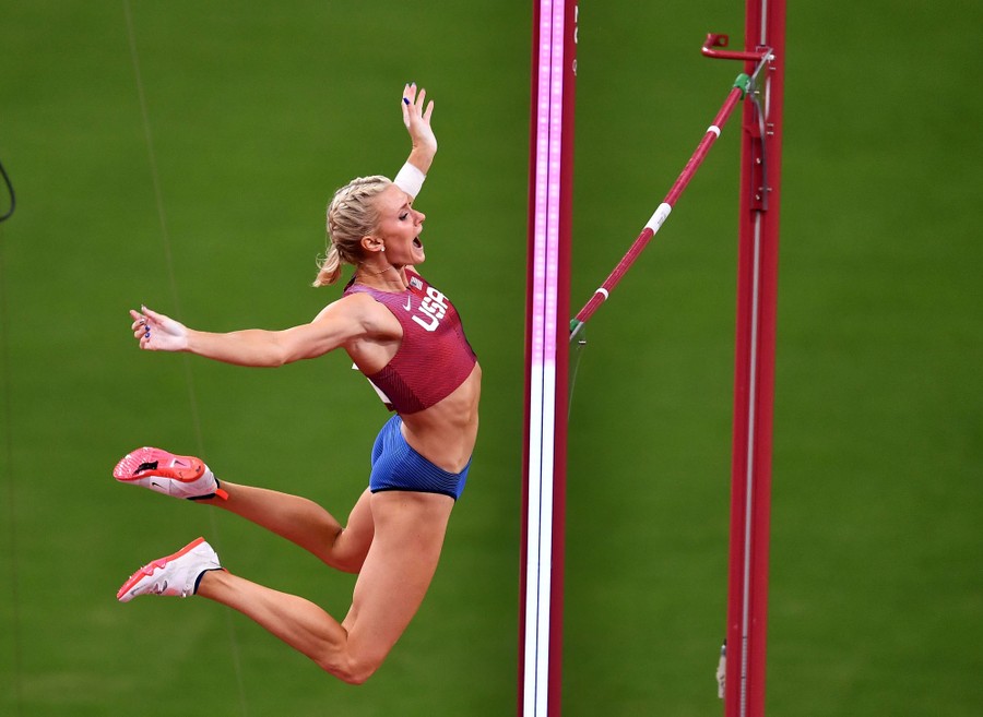 A pole vaulter falls after clearing a jump.