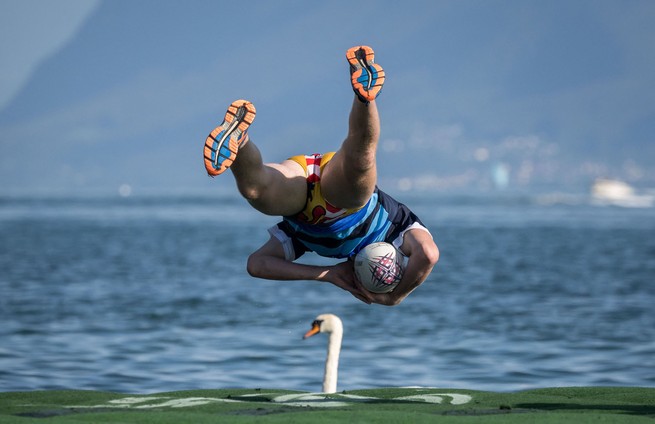 This picture, taken on September 2, 2023, shows a player scoring a try during Water Rugby Lausanne by jumping into Lake Geneva from a floating rugby field. The match was part of a three-day tournament organized by LUC Rugby that gathered more than 240 players in Lausanne, Switzerland.