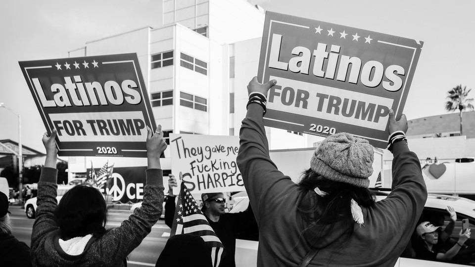 Two Trump supporters hold placards saying "Latinos for Trump" during a rally in Los Angeles.