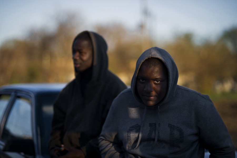 Donnell Glenn, 28, and Milan Ferrell-Garland, 15, lean on a car parked on Fletcher Street on Sunday, April 27, 2014. After the horsemen return from riding, they often hang out at the stable until late.