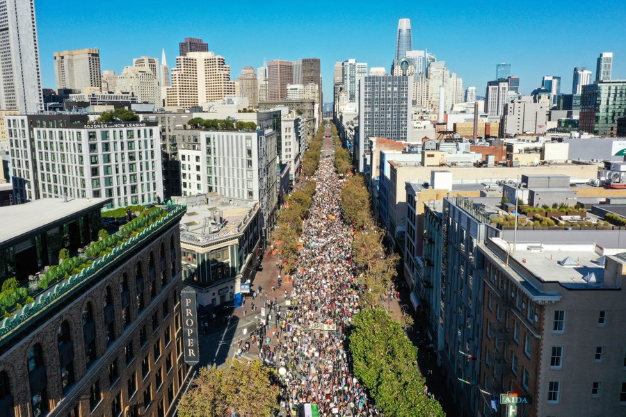 An elevated view of a city street full of marching protesters