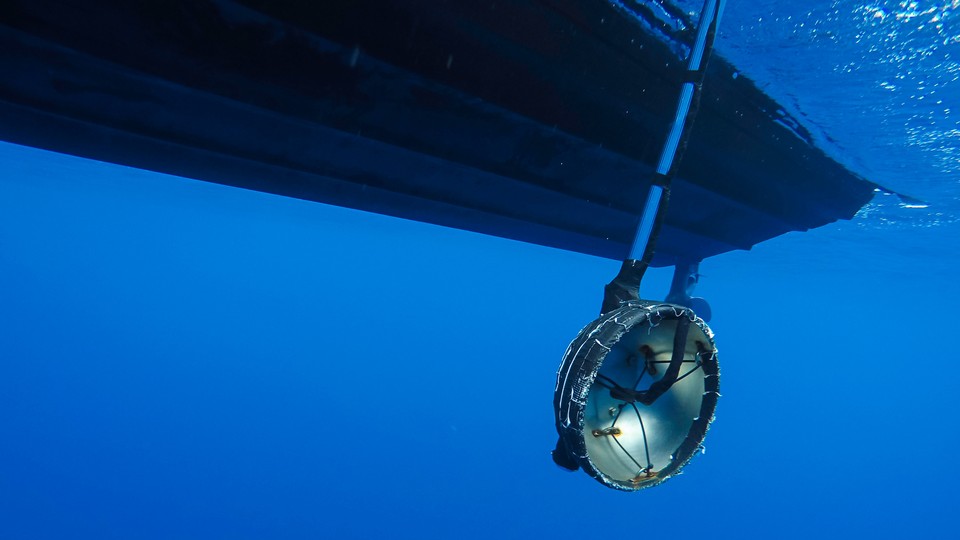 An underwater microphone hangs from a boat