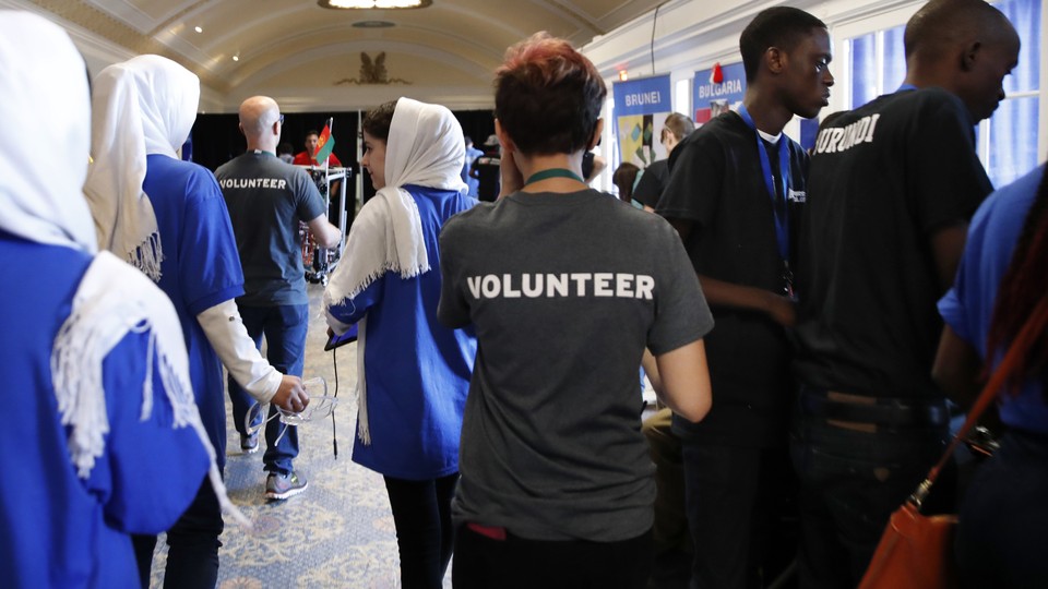 The Afghanistan team, left, walks past team members from Burundi, right, during the FIRST Global Robotics Challenge on July 17.