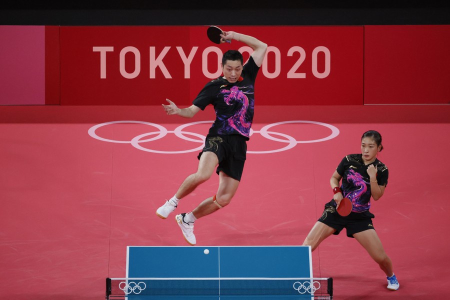 One member of a couple returns a table-tennis volley.