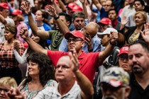 Congregation of evangelicals in church, some of them wearing MAGA caps