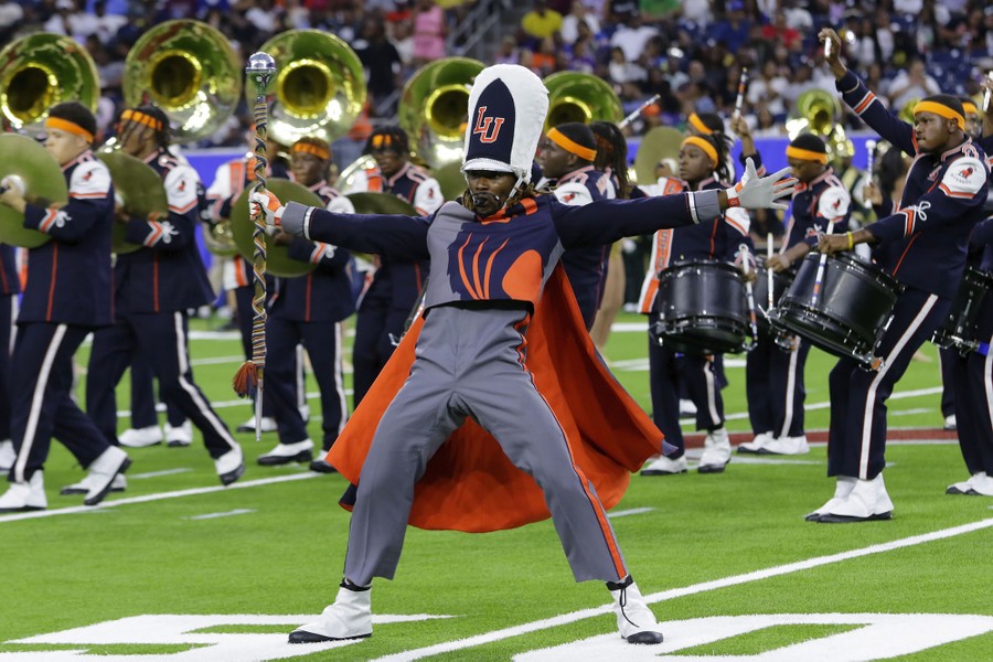 Members of a marching band perform on a football field.