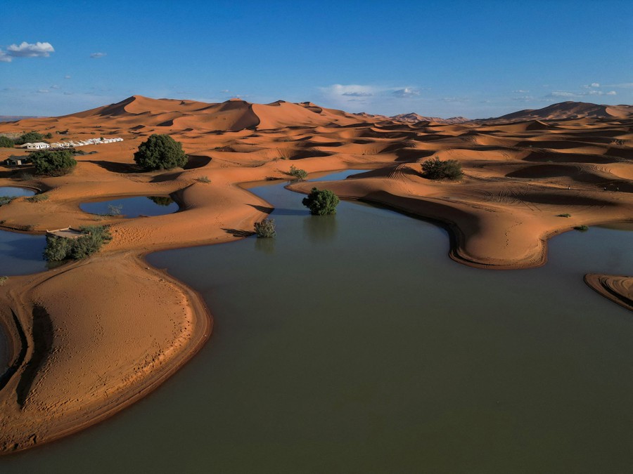 A drone view shows sand dunes partially covered by floodwaters.