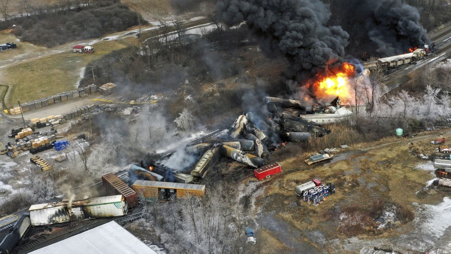 An aerial view of a derailed freight train on fire
