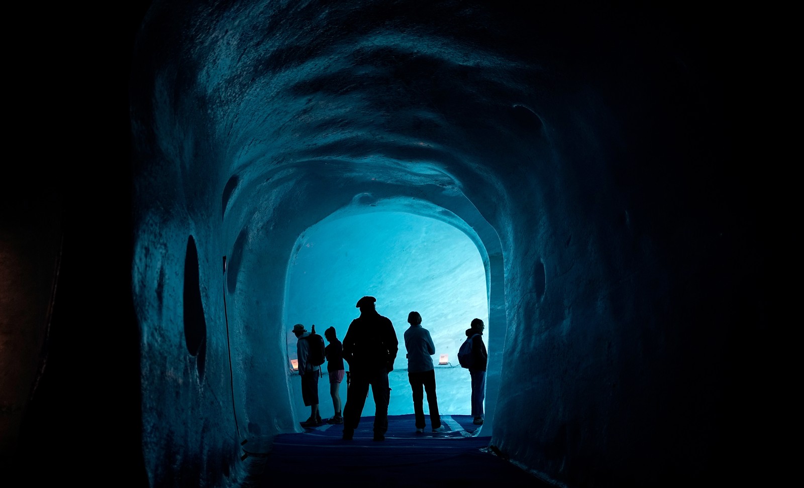 Five tourists stand in an ice cave.