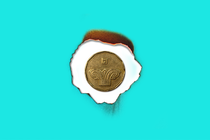 a coin against a burnt paper against a blue background