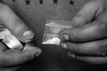 Hands holding a packet of white powder