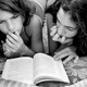 black and white photo of two girls reading a book