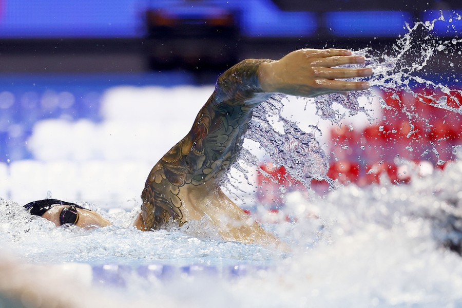 A swimmer splashes water from their arm during a race.