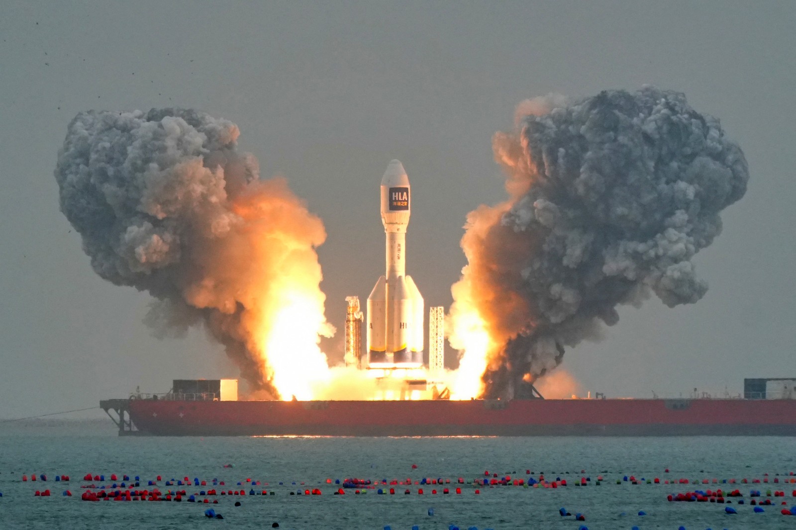 A large rocket lifts off from a ship.