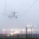 A plane landing on a foggy day