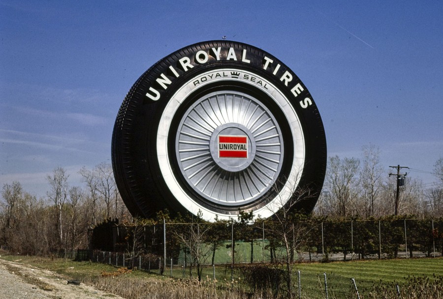 A giant Uniroyal tire stands along a highway.