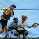 A player at bat strikes out while a Wiffle ball rests in the catcher's mitt.