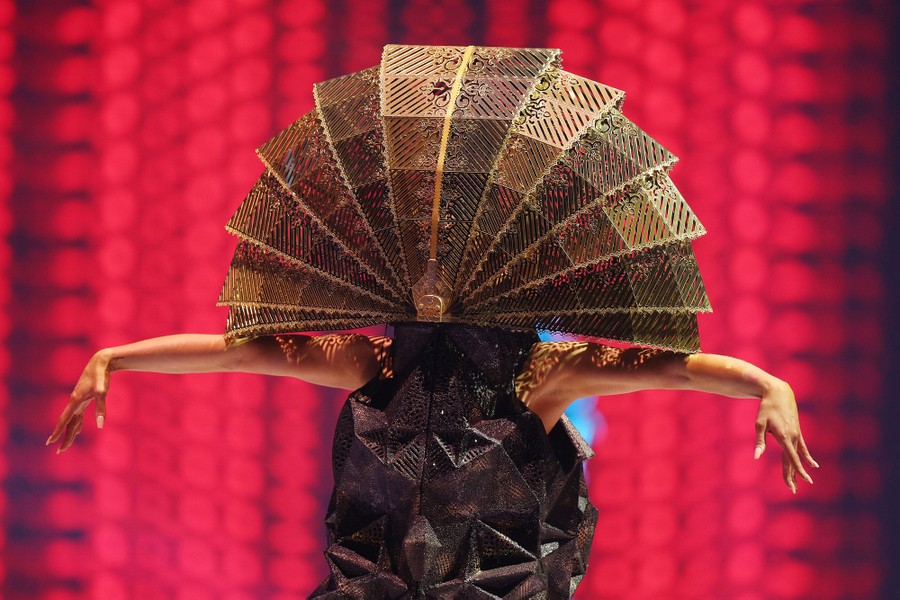 A person models a large dome-like head covering that appears to be collapsible.