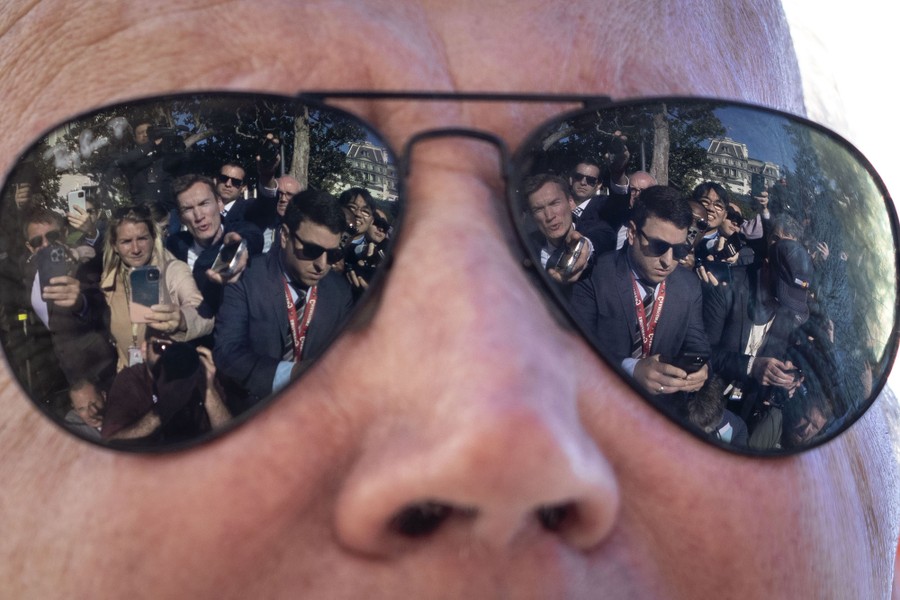 Reporters are reflected in the sunglasses of President Joe Biden.