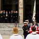 Photo of the Cheney family outside the National Cathedral watching as men in uniform carry Dick Cheney's casket.